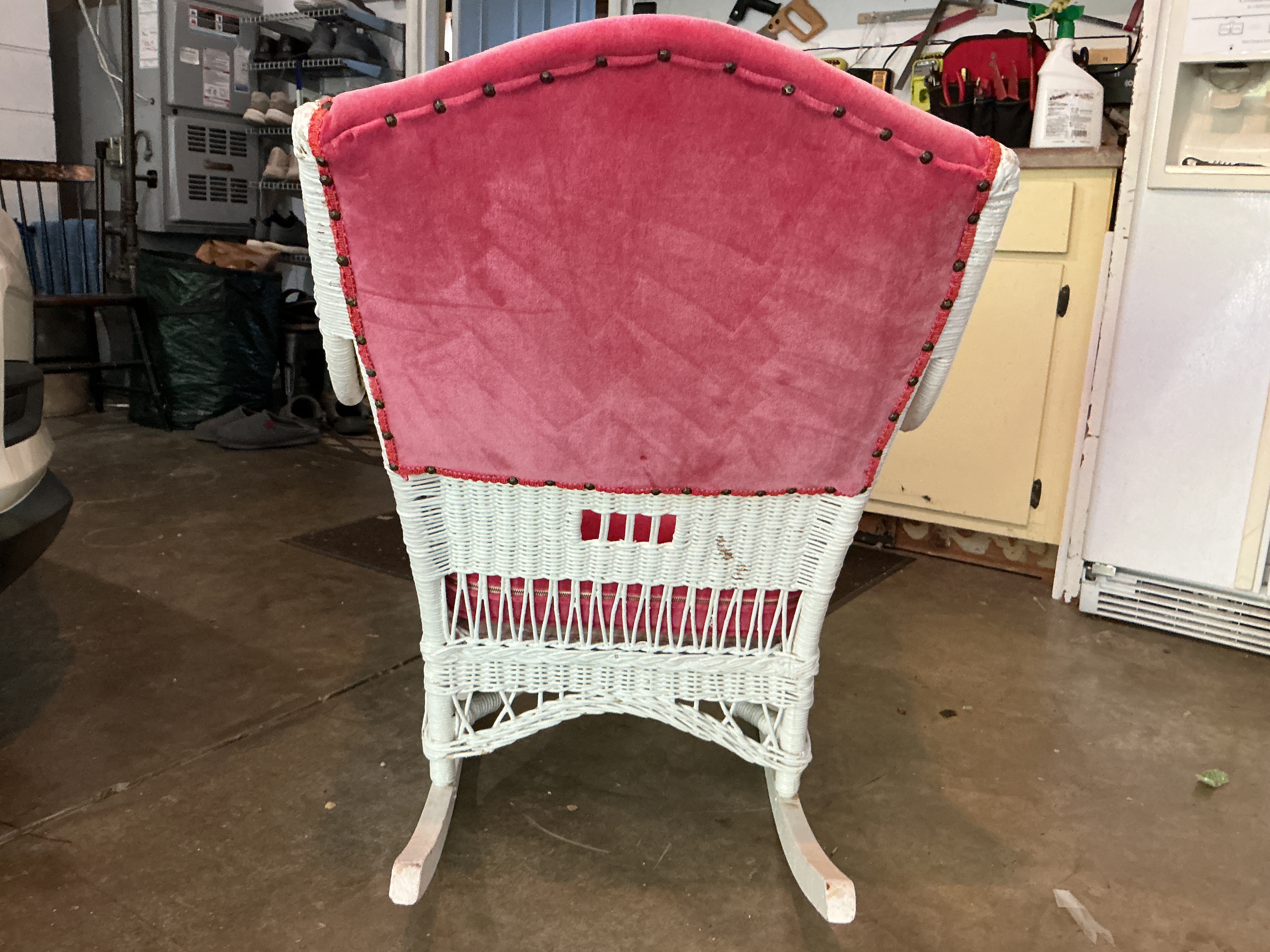 White wicker rocking chair with cushion and upholstered back