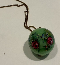 Large glass bead with hand decorated flowers that appear to be under glass mint green