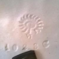 there is a finishers dot at the 8 o'clock  position. anyone know who the finishers is? the dot in the pic is very fant, it is to the left of the flames.