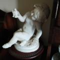 Baby girl with bird in hand alabaster or marble statue on a wooden pedestal